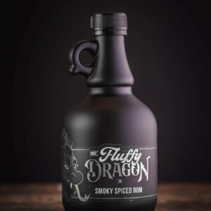 A photo of The Fluffy Dragon Co black bottle on a wooden table with the smoky spiced rum label