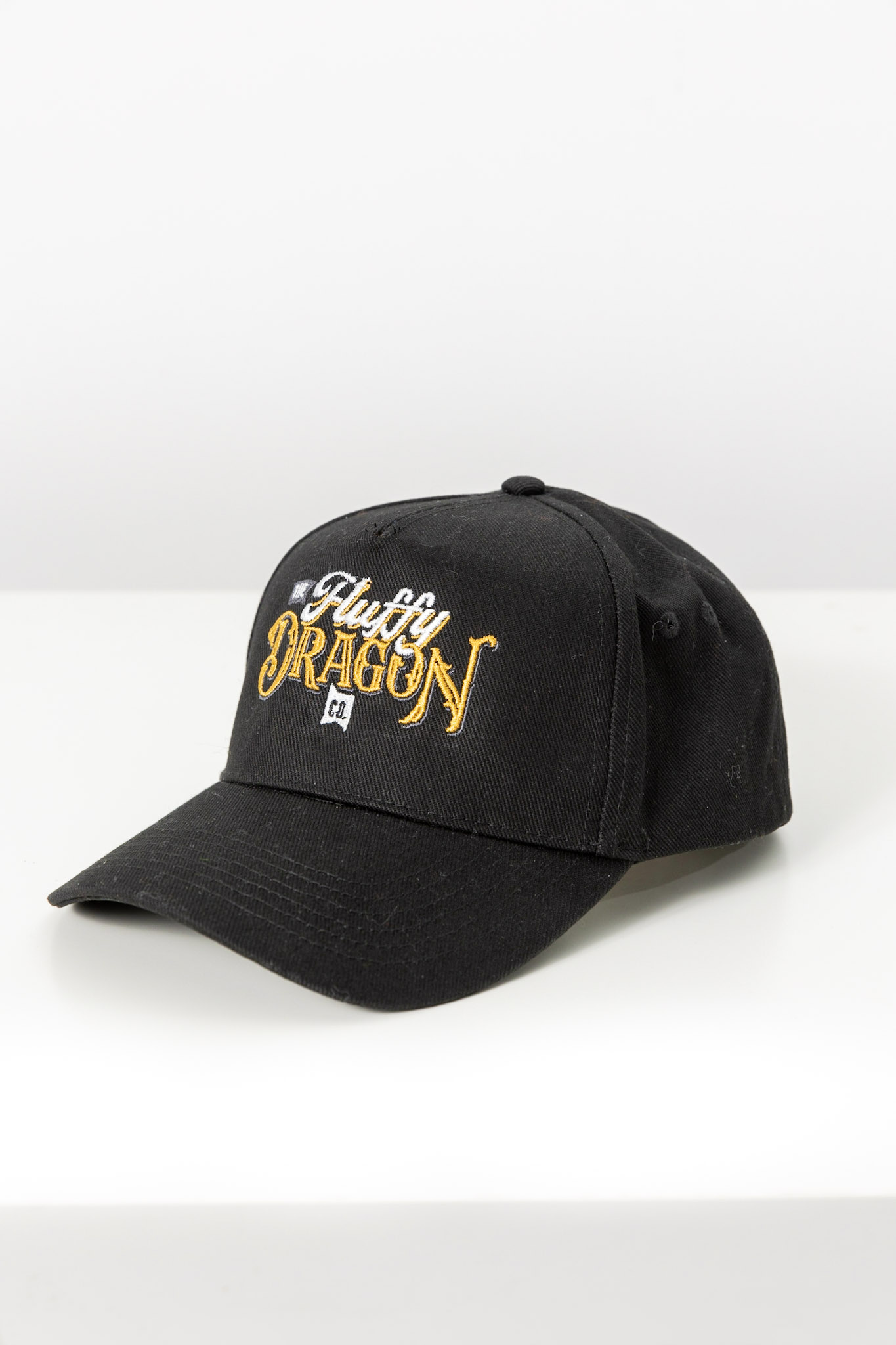 A black trucker hat with The Fluffy Dragon Co logo